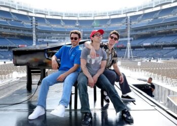 Kevin, Joe e Nick Jonas no palco antes da noite de abertura da turnê "Five Albums, One Night" no Yankee Stadium Kevin Mazur/Getty Images for Live Nation