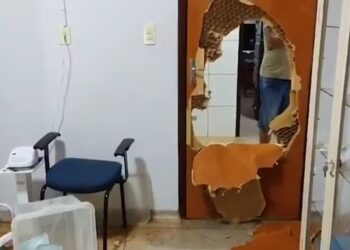 Porta fica destruída após criminosos invadirem unidade de saúde para matar homem