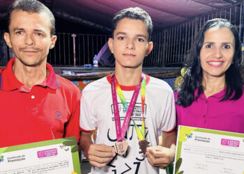 Estudante João Vitor e seus pais durante a solenidade de entrega das medalhas
