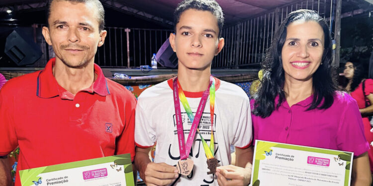 Estudante João Vitor e seus pais durante a solenidade de entrega das medalhas