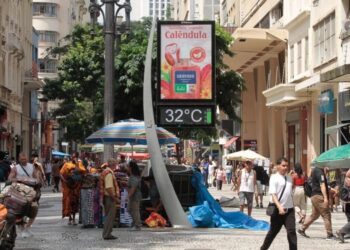 Pedestres se protegem do calor na região central da cidade de São Paulo