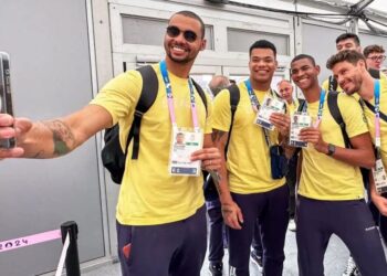 Atletas de vôlei de quadra masculino do Time Brasil fazem foto na chegada à Vila Olímpica Marina Ziehe/COB
