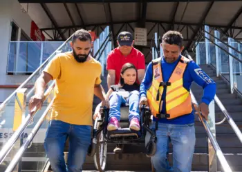 A cadeirante Jenaria Barboza de Araújo precisa de ajuda de três homens para conseguir acesso ao restaurante que fica no segundo piso, local não tem rampa de acesso e nem elevador