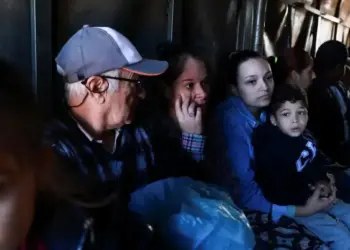 Sobreviventes sentam em caminhão enquanto são retirados em Porto Alegre, no Rio Grande do Sul