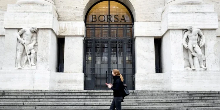 Pedestre caminha em frente à Bolsa de Valores de Milão • Flavio Lo Scalzo/Reuters