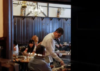 Garçom serve clientes em restaurante no Brooklyn, cidade de Nova York, EUA • 12/08/2021REUTERS/Andrew Kelly