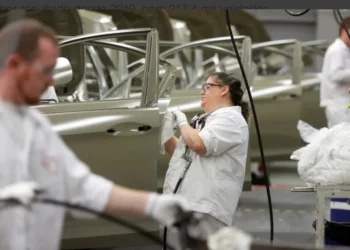 Funcionário na linha de produção de veículos • Foto: Paul Vernon/Reuters