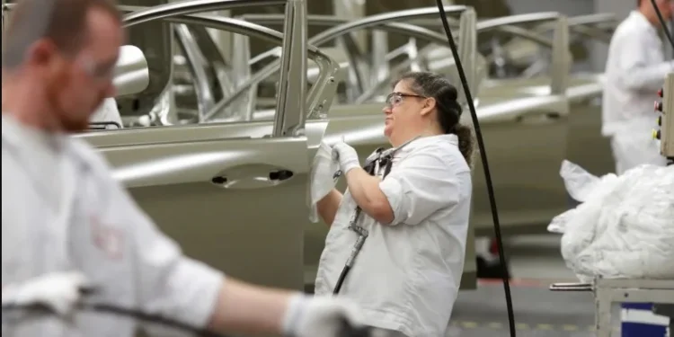 Funcionário na linha de produção de veículos • Foto: Paul Vernon/Reuters