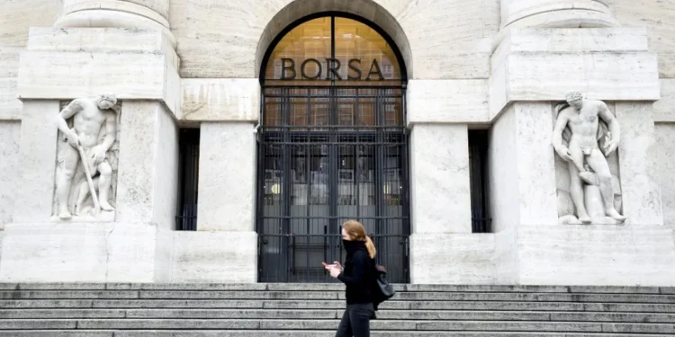 Pedestre caminha em frente à Bolsa de Valores de Milão • Flavio Lo Scalzo/Reuters