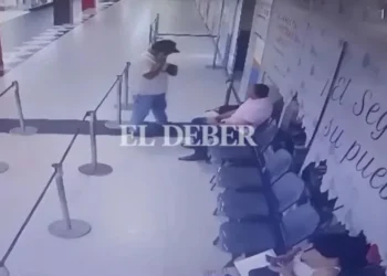 Policial à esquerda, de camiseta branca, e Tuta sentado à direita, de camiseta rosa. • Reprodução/El Deber