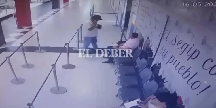 Policial à esquerda, de camiseta branca, e Tuta sentado à direita, de camiseta rosa. • Reprodução/El Deber