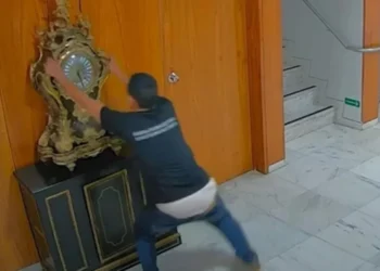 O mecânico Antônio Cláudio Alves Ferreira quebrando o relógio histórico no 8 de Janeiro • Reprodução