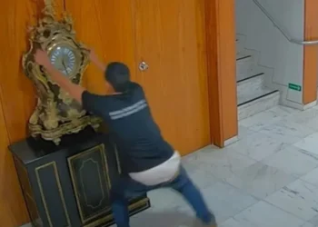 O mecânico Antônio Cláudio Alves Ferreira quebrando o relógio histórico no 8 de Janeiro • Reprodução