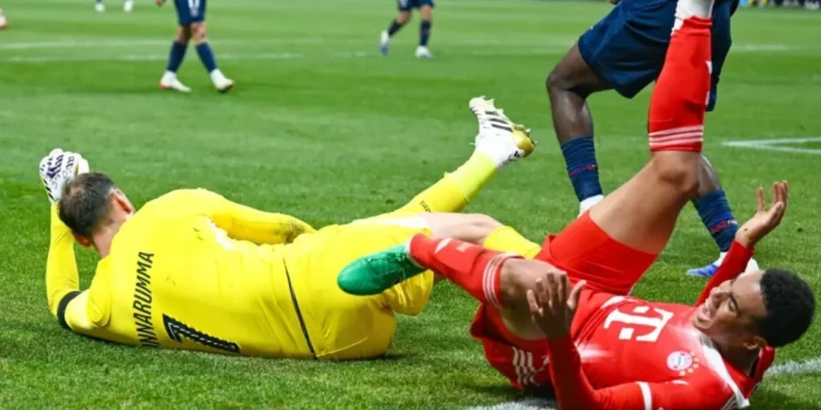 Musiala cai no gramado após choque com o goleiro Donnarumma  • Rich von Biberstein/Icon Sportswire via Getty Images