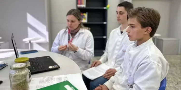 A professora Jessica Pandini Klauck orienta a pesquisa dos jovens João Pedro Decarli e Leonardo Schroder Volkweis — Foto: Biopark/Divulgação
