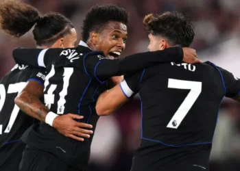 Estêvão comemora com Pedro Neto e Malo Gusto a assistência que deu para o gol de Enzo Fernández • John Walton/PA Images via Getty Images